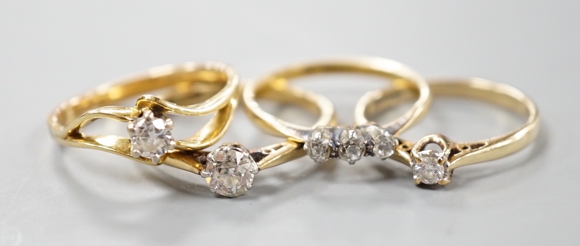 Two 18ct and solitaire diamond rings, an 18ct and three stone diamond ring, gross 7.8 grams and a 9ct and solitaire diamond ring, gross 1.8 grams.